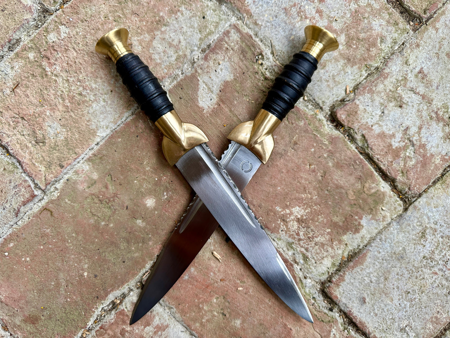 18thC short brass and black wood dirk. Two knives crossed.