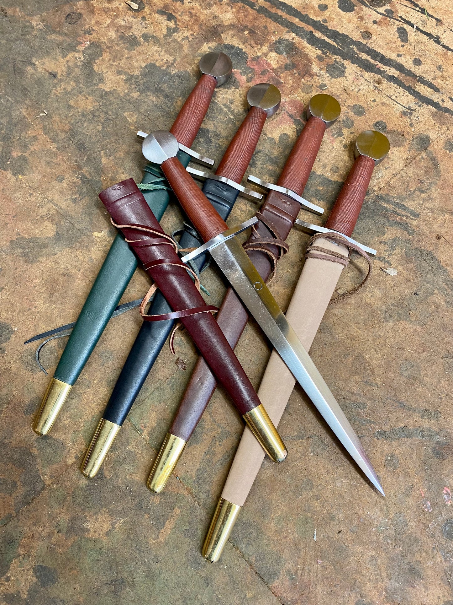 
                  
                    Tod Cutler Quillon daggers with red, brown, black, green and natural scabbards
                  
                