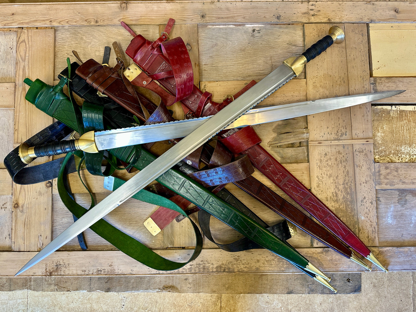 two crossed swirks on a pile of green black, brown and red scabbards