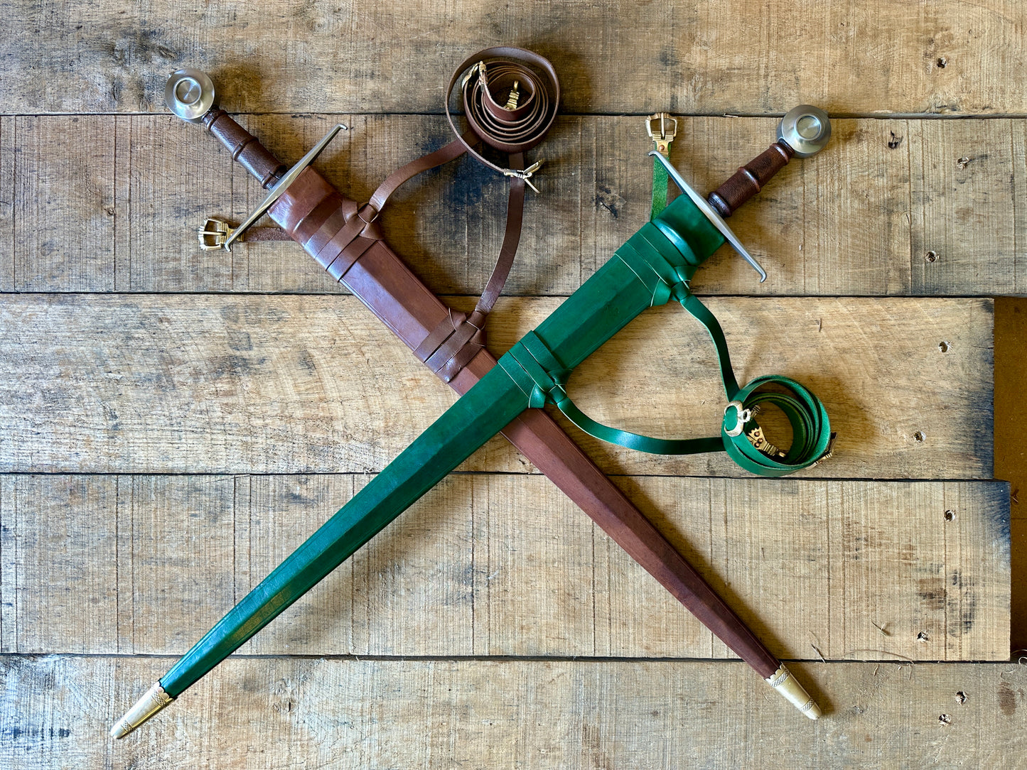 
                  
                    Castillon single handed sword. Two swords crossed, one in a green scabbard and one in a brown scabbard
                  
                