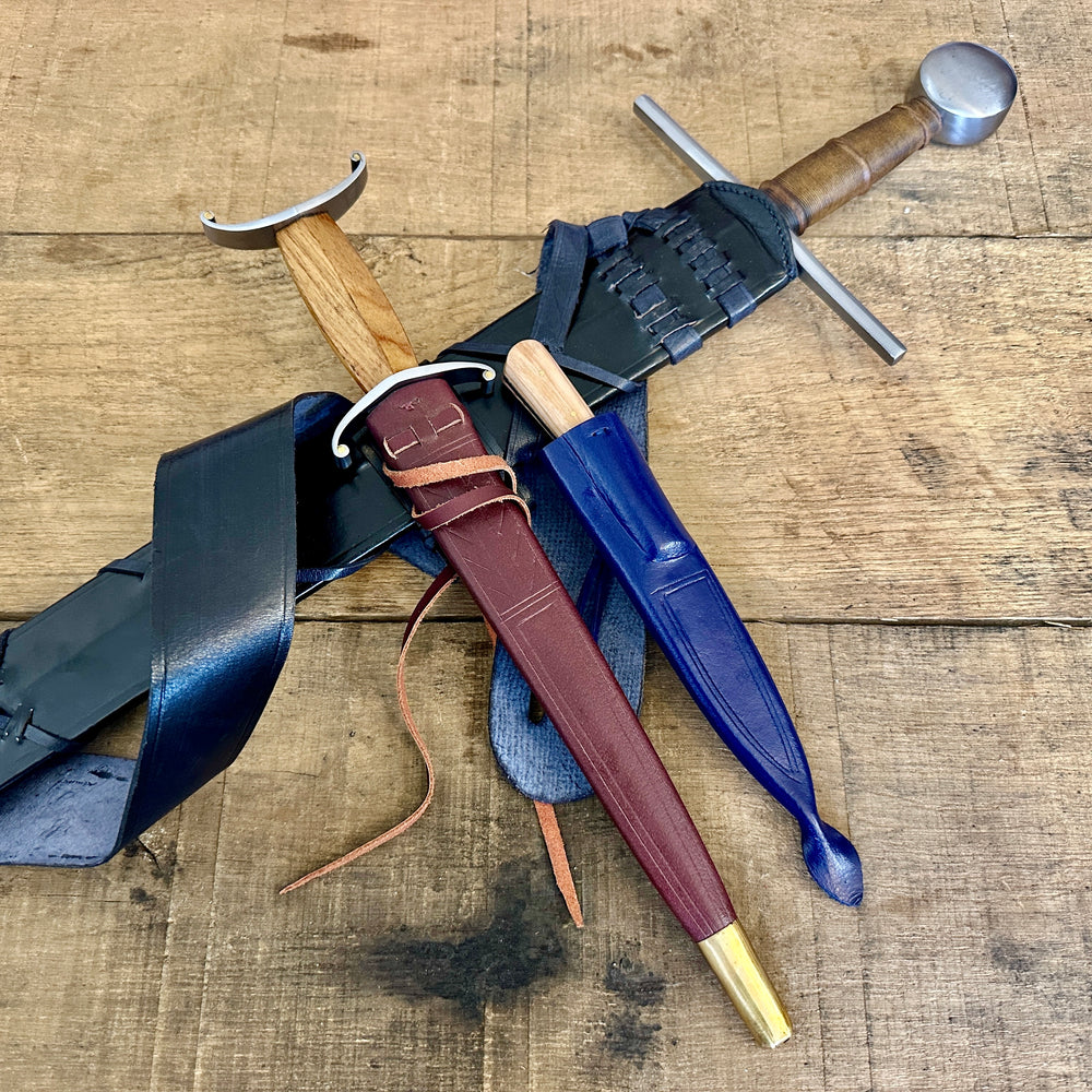 
                  
                    12th Century single-handed sword, 11-14th Century Antennae Dagger and 12-14th Century Peasants eating knife crossed close up (in scabbards)
                  
                