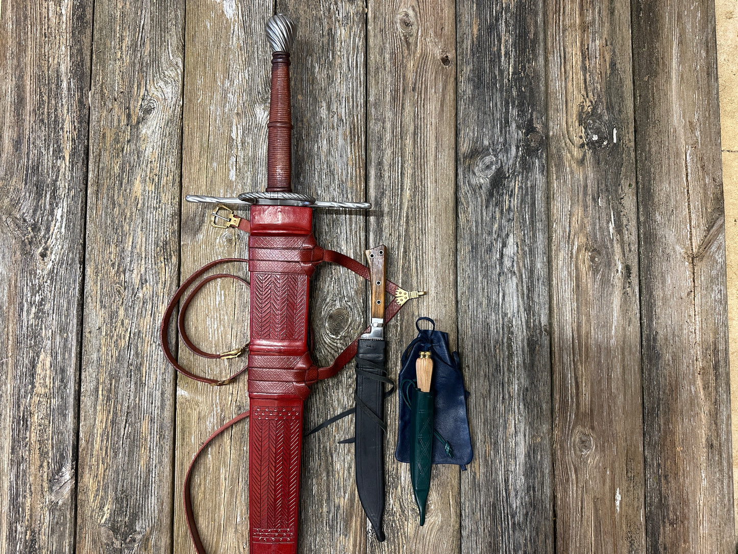 
                  
                    The Big Weapon Bundle. Sword, knife, eating set in sheathes and featuring a leather pouch. 
                  
                