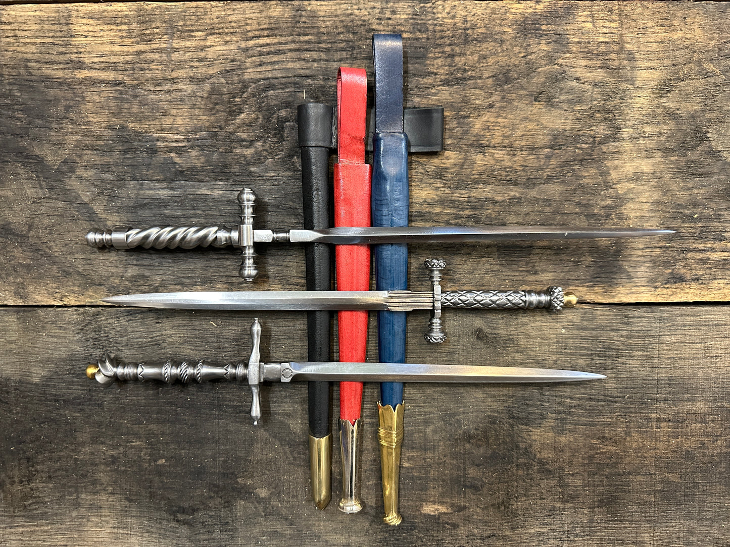 three stilettos resting on black, red and blue sheathes
