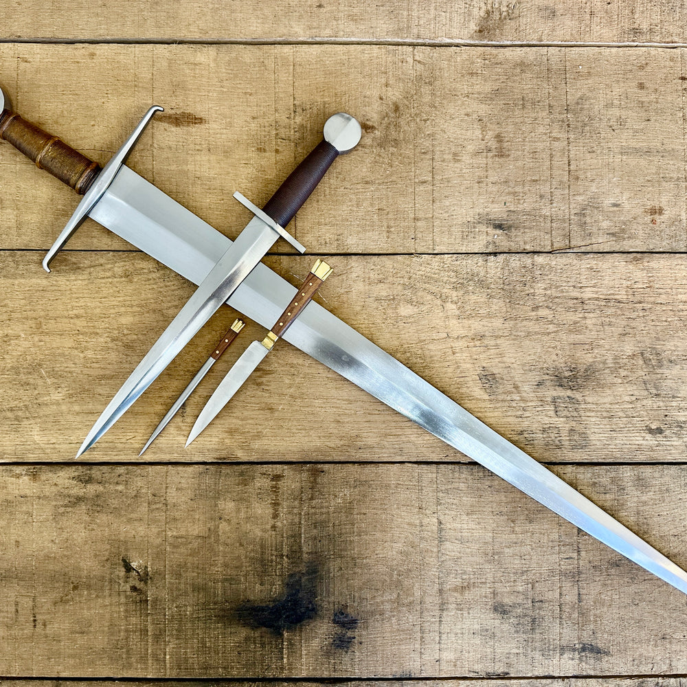 
                  
                    15th Century single handed sword, 12th - 17th century quillon dagger and 15th century two-piece eating set (no scabbards)
                  
                