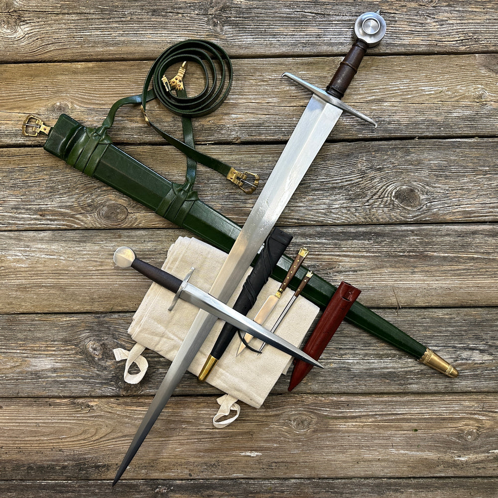 Castillon bundle with a sword and green scabbard, a quillon dagger with black scabbard and an eating set with knife and pricker and a red scabbard. There is also a free cotton sword bag.