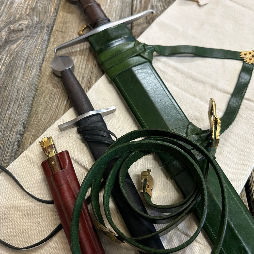
                  
                    Castillon bundle with a sword and green scabbard, a quillon dagger with black scabbard and an eating set with knife and pricker and a red scabbard. There is also a free cotton sword bag.
                  
                