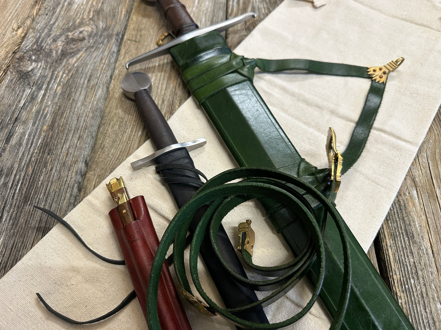 
                  
                    Castillon bundle with a sword and green scabbard, a quillon dagger with black scabbard and an eating set with knife and pricker and a red scabbard. There is also a free cotton sword bag.
                  
                