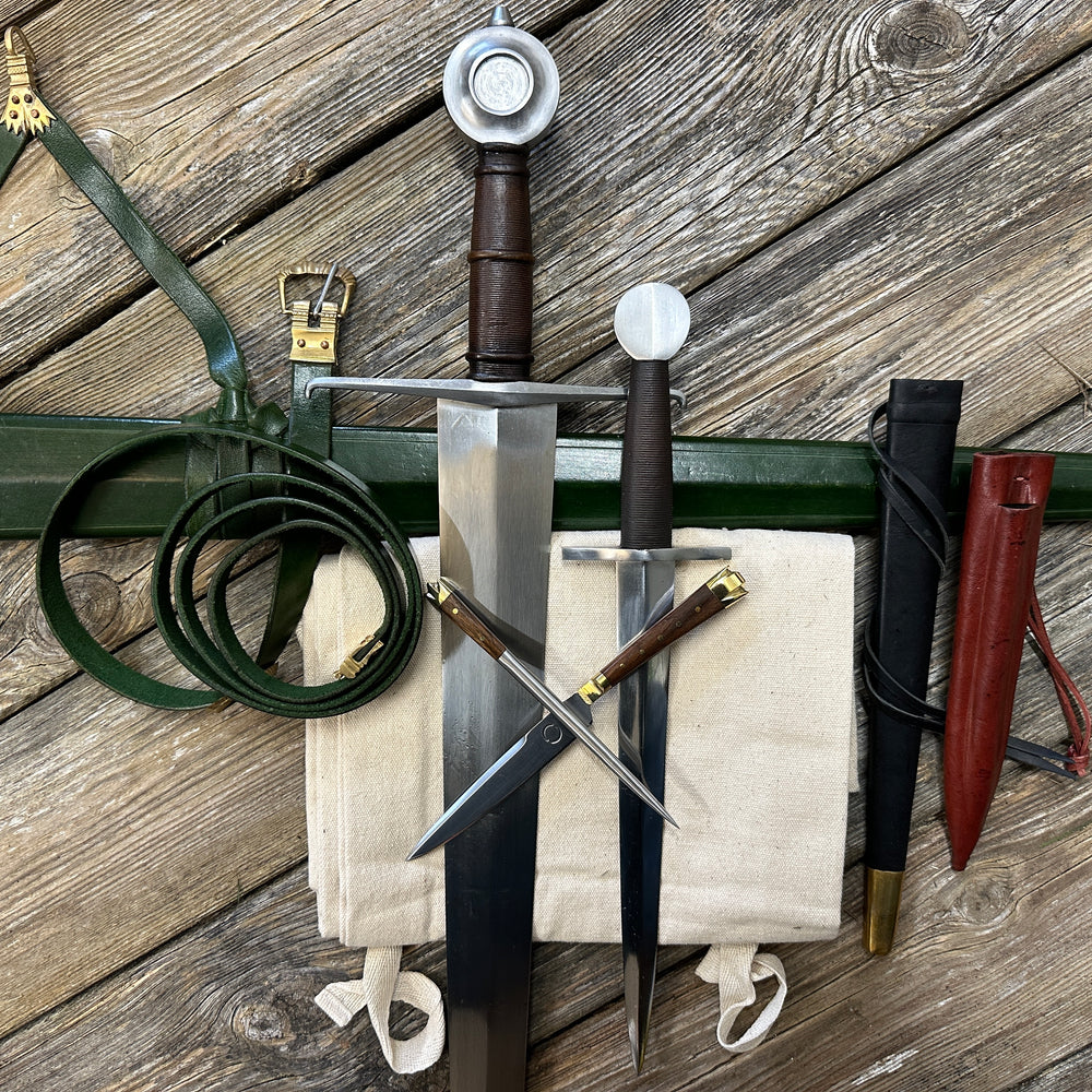 Castillon bundle with a sword and green scabbard, a quillon dagger with black scabbard and an eating set with knife and pricker and a red scabbard. There is also a free cotton sword bag.
