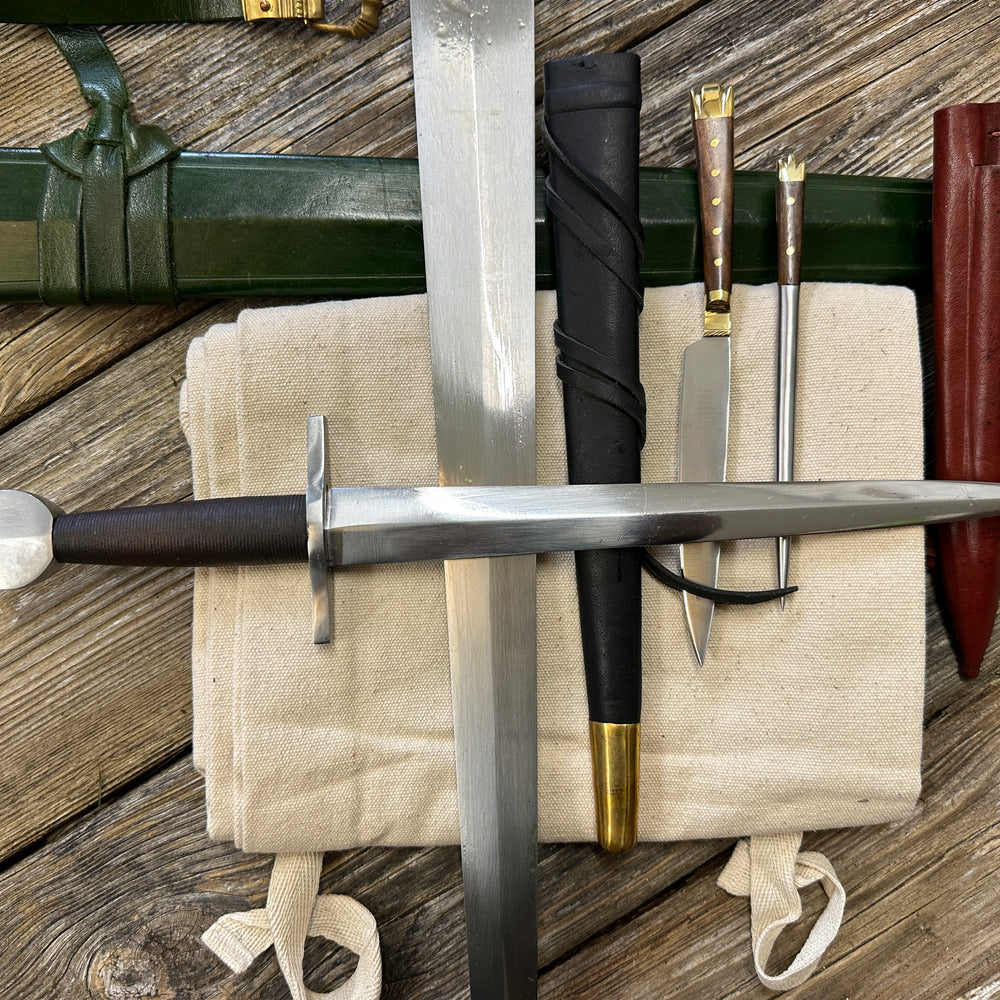 
                  
                    Castillon bundle with a sword and green scabbard, a quillon dagger with black scabbard and an eating set with knife and pricker and a red scabbard. There is also a free cotton sword bag.
                  
                