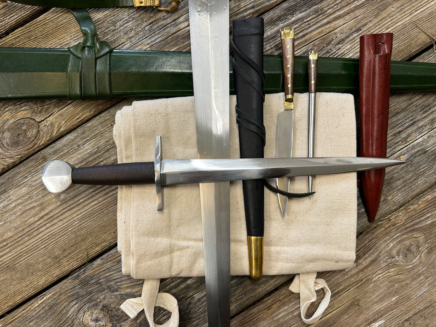 
                  
                    Castillon bundle with a sword and green scabbard, a quillon dagger with black scabbard and an eating set with knife and pricker and a red scabbard. There is also a free cotton sword bag.
                  
                