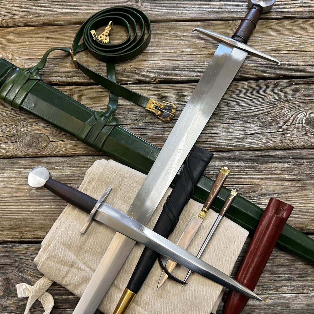 
                  
                    Castillon bundle with a sword and green scabbard, a quillon dagger with black scabbard and an eating set with knife and pricker and a red scabbard. There is also a free cotton sword bag.
                  
                