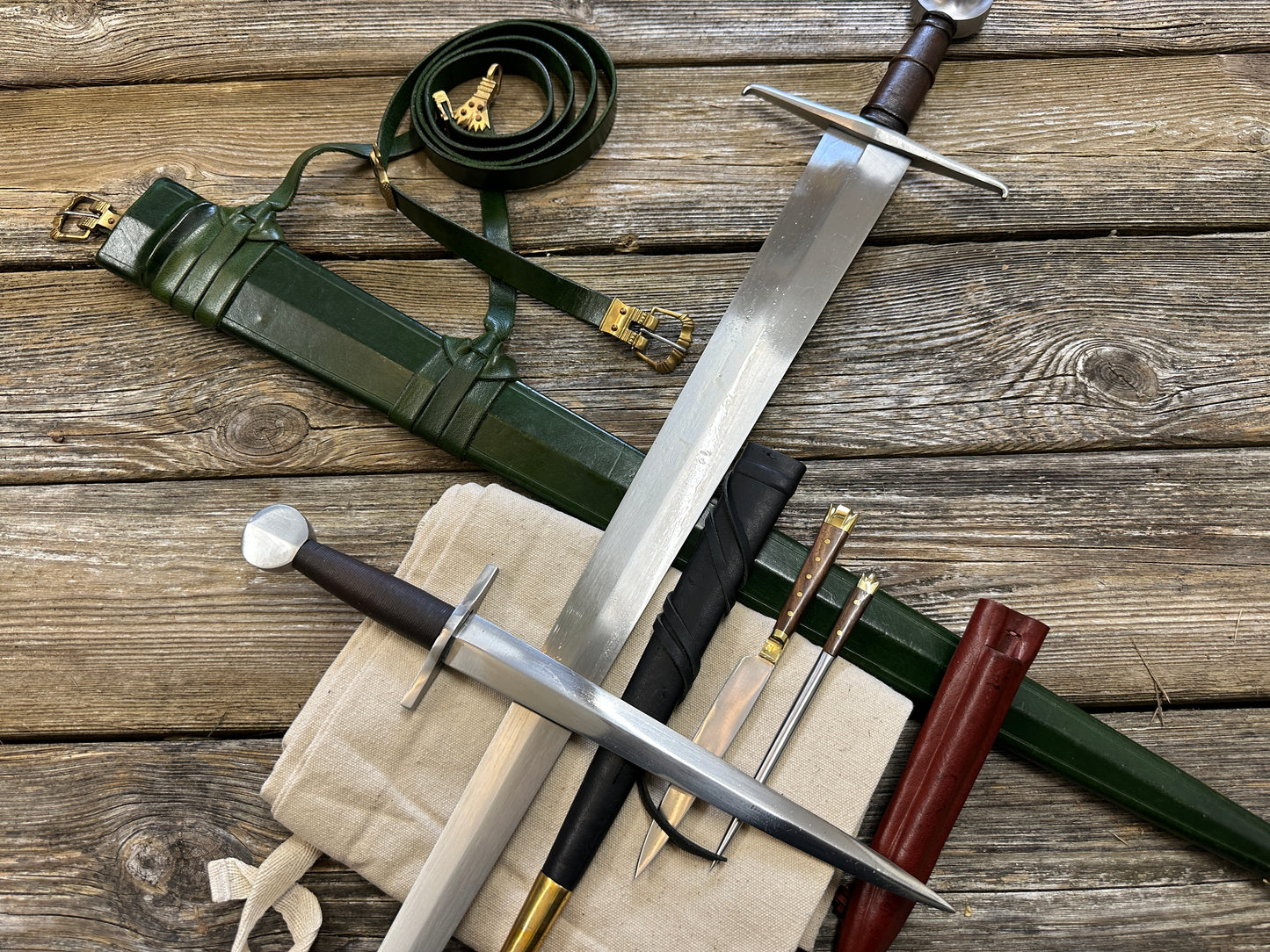 
                  
                    Castillon bundle with a sword and green scabbard, a quillon dagger with black scabbard and an eating set with knife and pricker and a red scabbard. There is also a free cotton sword bag.
                  
                
