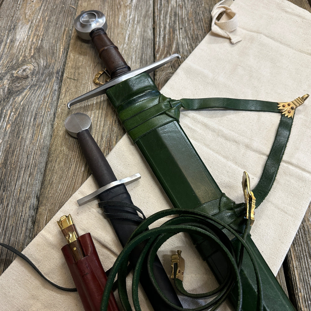 
                  
                    Castillon bundle with a sword and green scabbard, a quillon dagger with black scabbard and an eating set with knife and pricker and a red scabbard. There is also a free cotton sword bag.
                  
                