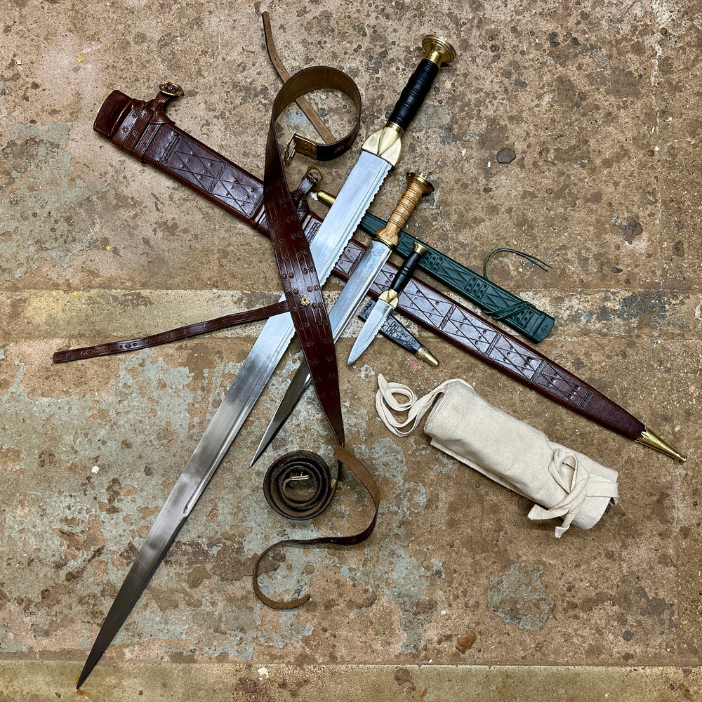 Swirk, Scottish Dirk and Sgian Dhu with their scabbards in a pile with a rolled up sword bag next to them. 