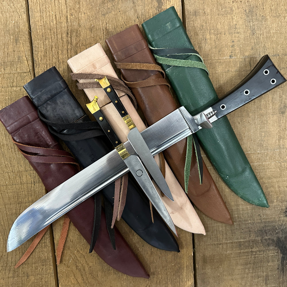 
                  
                    Bauernwehr with by knives resting on red, black, natural, brown and green scabbards
                  
                