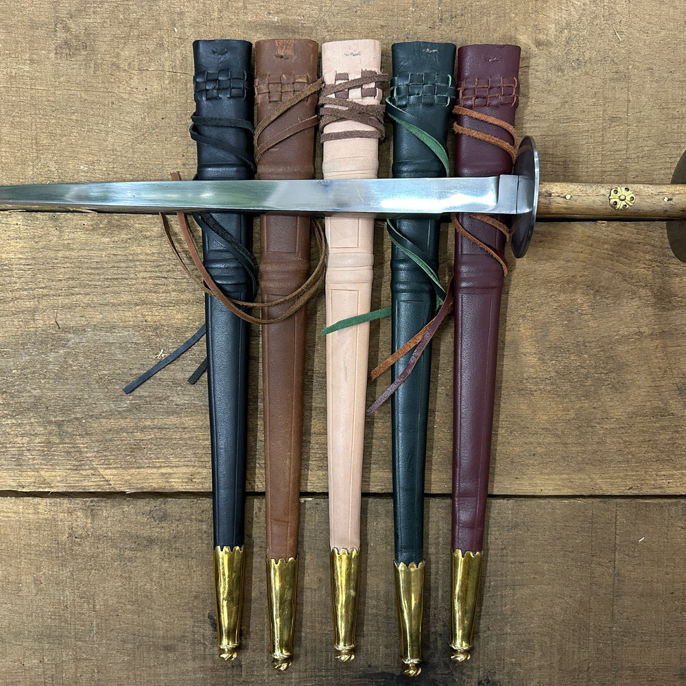 Wallace Rondel laying on a black, brown, natural, green and red scabbard