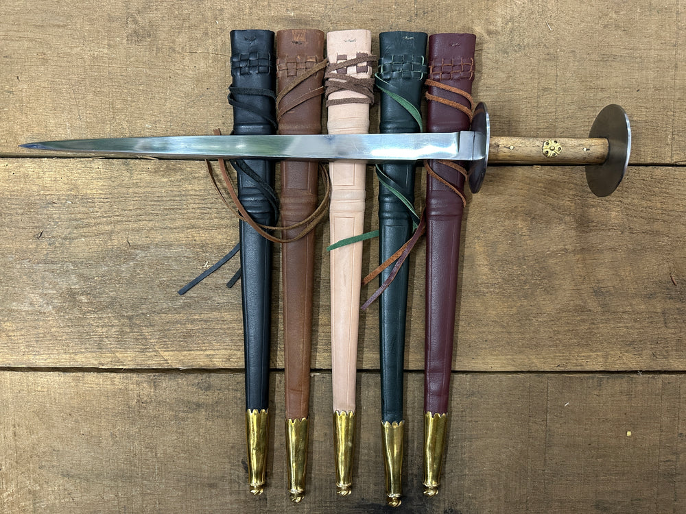 Wallace Rondel laying on a black, brown, natural, green and red scabbard