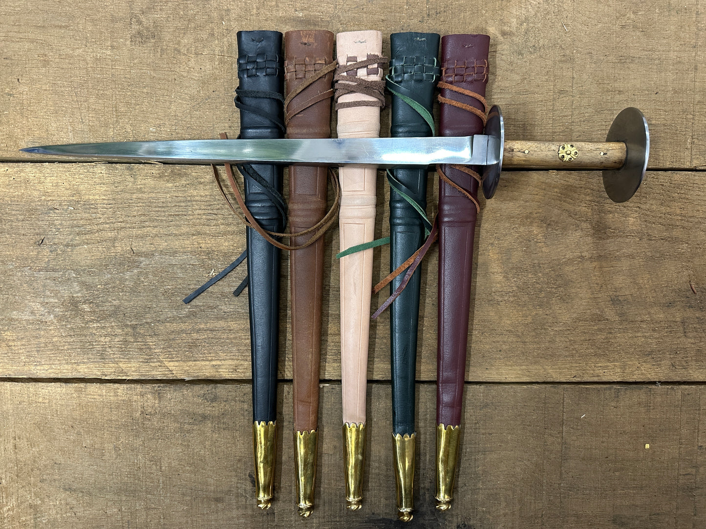 Wallace Rondel laying on a black, brown, natural, green and red scabbard