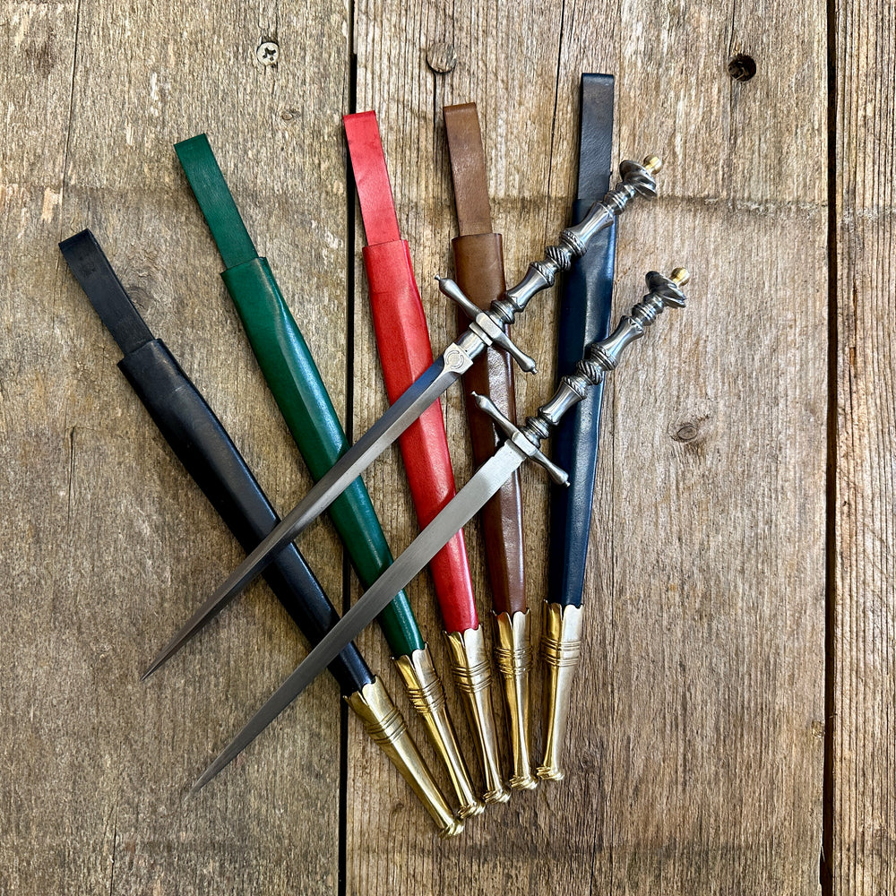 
                  
                    Two Pitt Rivers Stiletto daggers on blue, green, red, brown and black sheathes.
                  
                