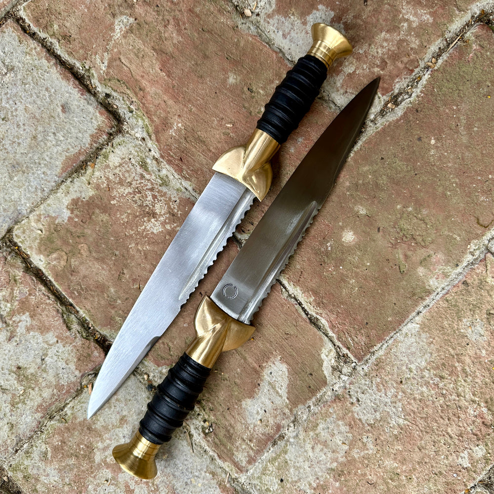 
                  
                    18thC Short brass and black wood dirk. Two opposing knives. 
                  
                