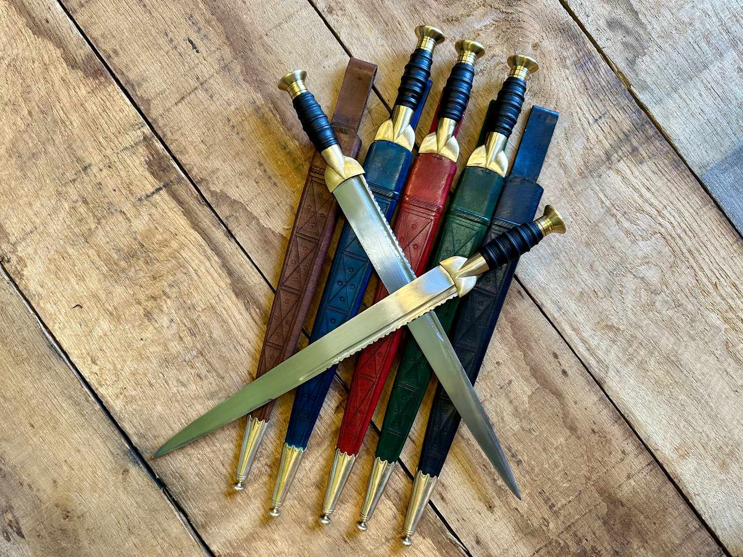 
                  
                    18thC long brass and wood dirk. Two knives in all scabbards.
                  
                