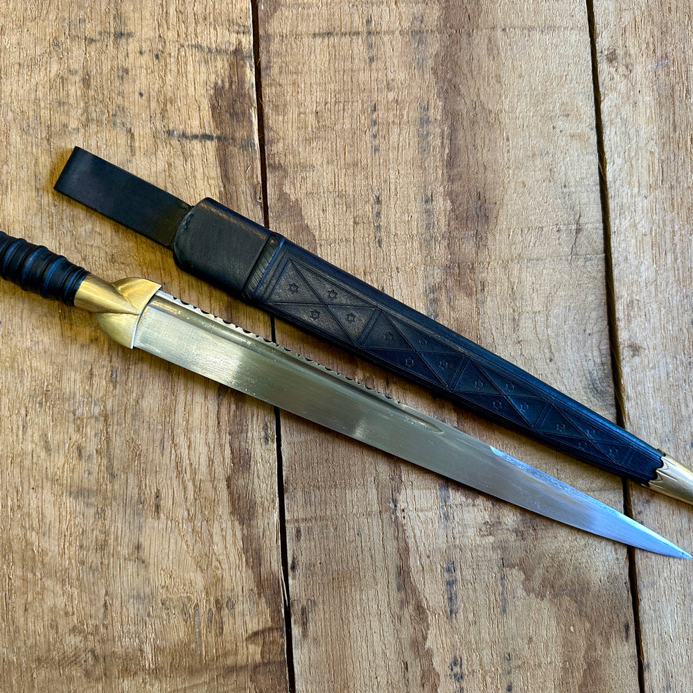 
                  
                    18thC long brass and wood dirk.With black scabbard. 
                  
                