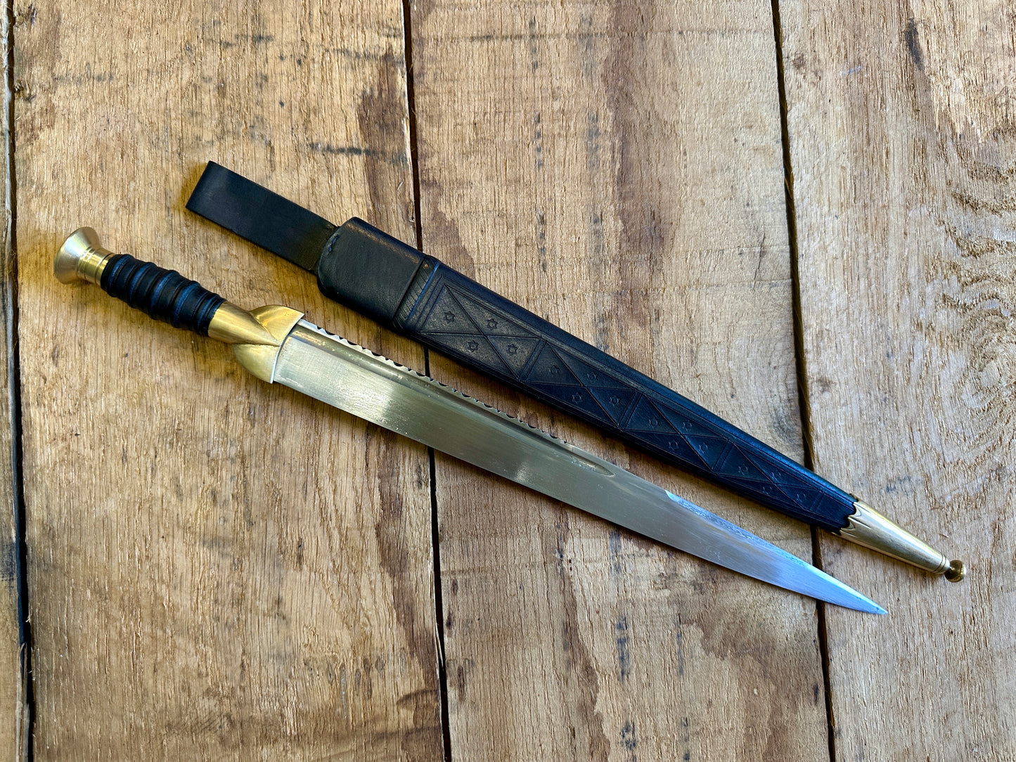 
                  
                    18thC long brass and wood dirk.With black scabbard. 
                  
                