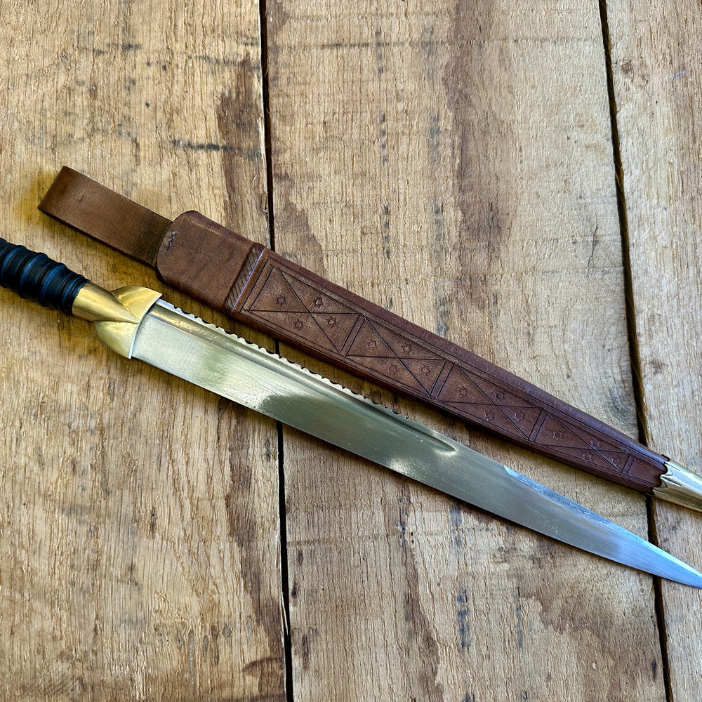 
                  
                    18thC long brass and wood dirk. With brown scabbard.
                  
                