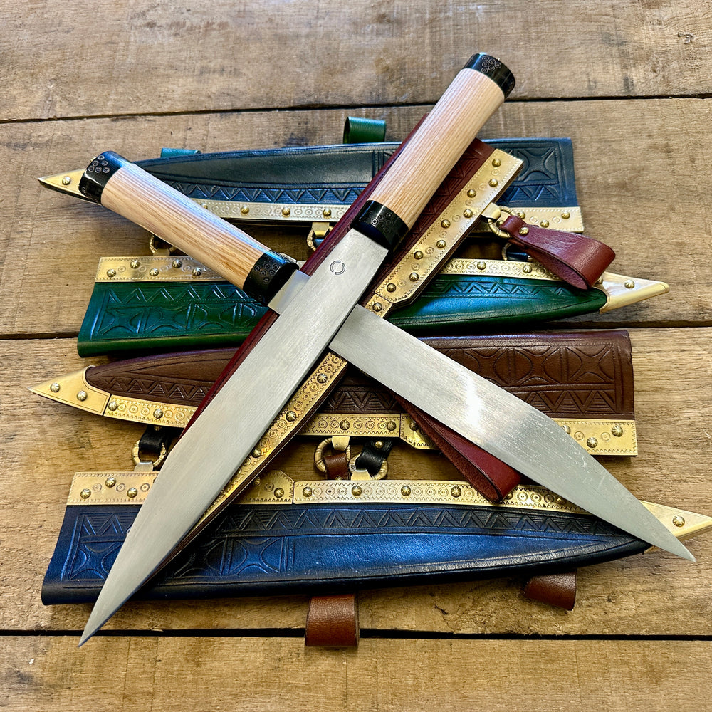 
                  
                    Decorated Anglo Saxon/Viking knives with scabbards in blue, green, red, brown and black.
                  
                