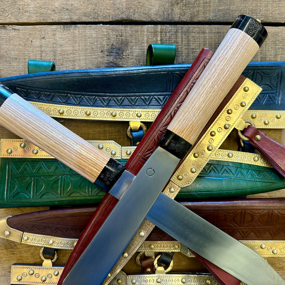 
                  
                    Decorated Anglo Saxon/Viking knives with leather sheathes, close up in blue, red, green and brown leather. 
                  
                