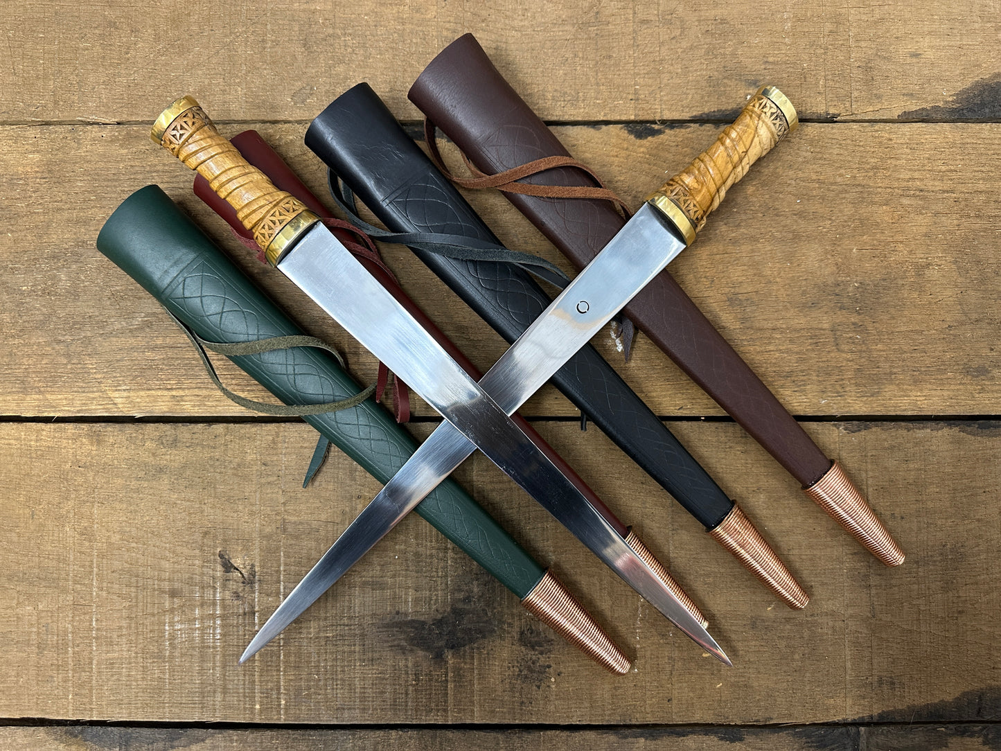 Two Long Irish Skean displayed on green, red, black and brown sheathes. 