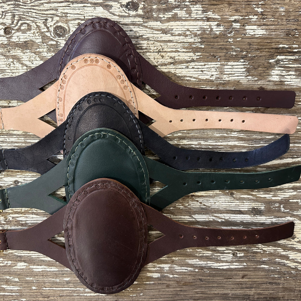 Oval archery bracers in a row descending from red, natural, black, green and brown