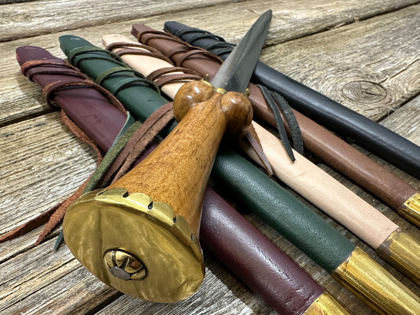 Mid status bollock dagger resting on a bed of scabbards and viewed from the top down