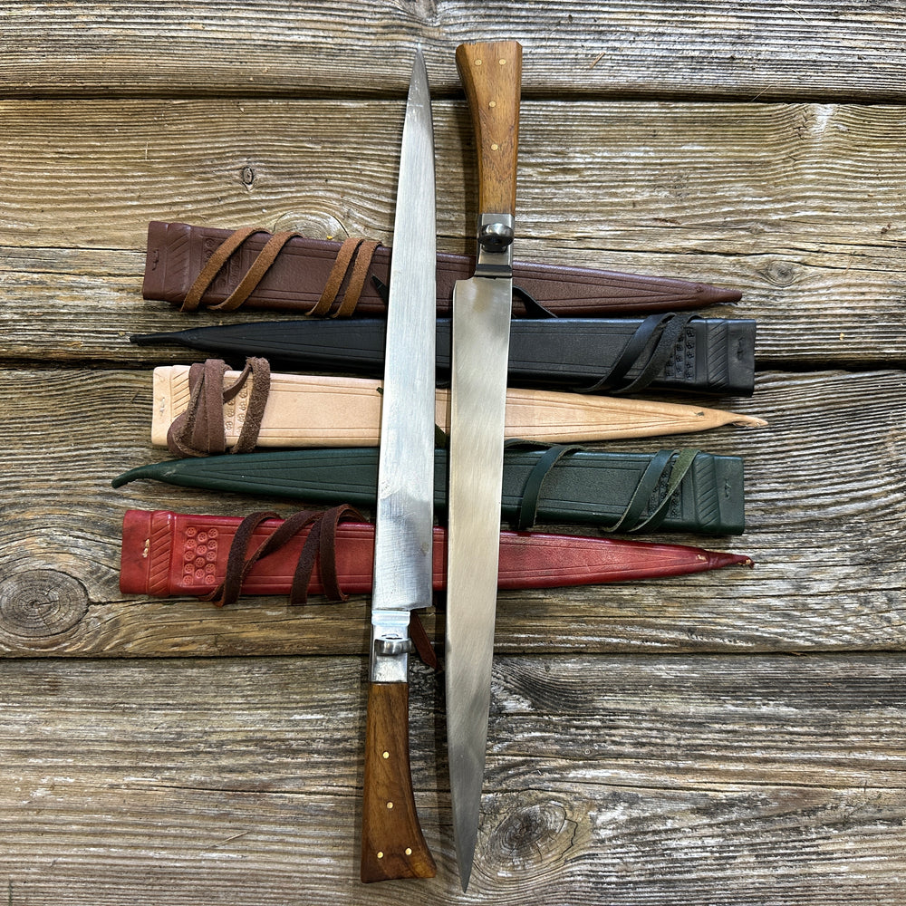 
                  
                    Rugger Bauernwehr. Two knives on brown, black, natural, green and red scabbards. 
                  
                