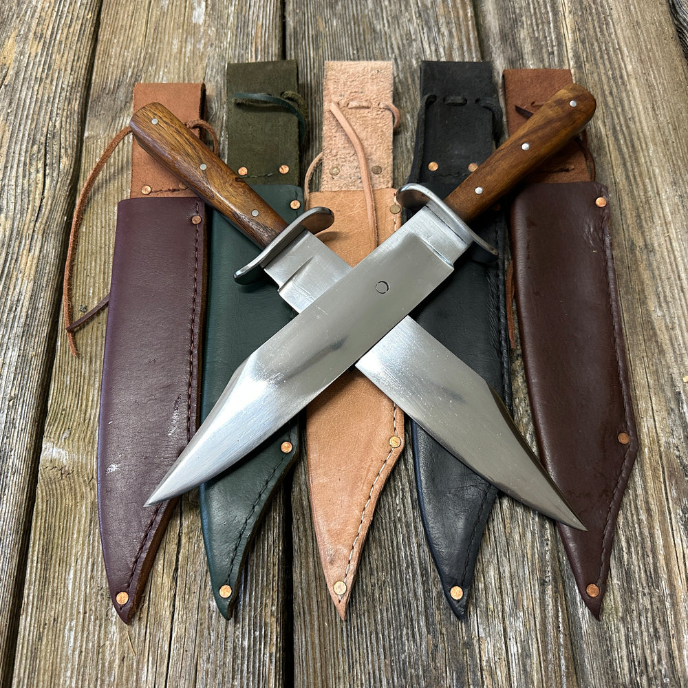 Two Bowie knives crossed on red, green, natural, black and brown scabbards