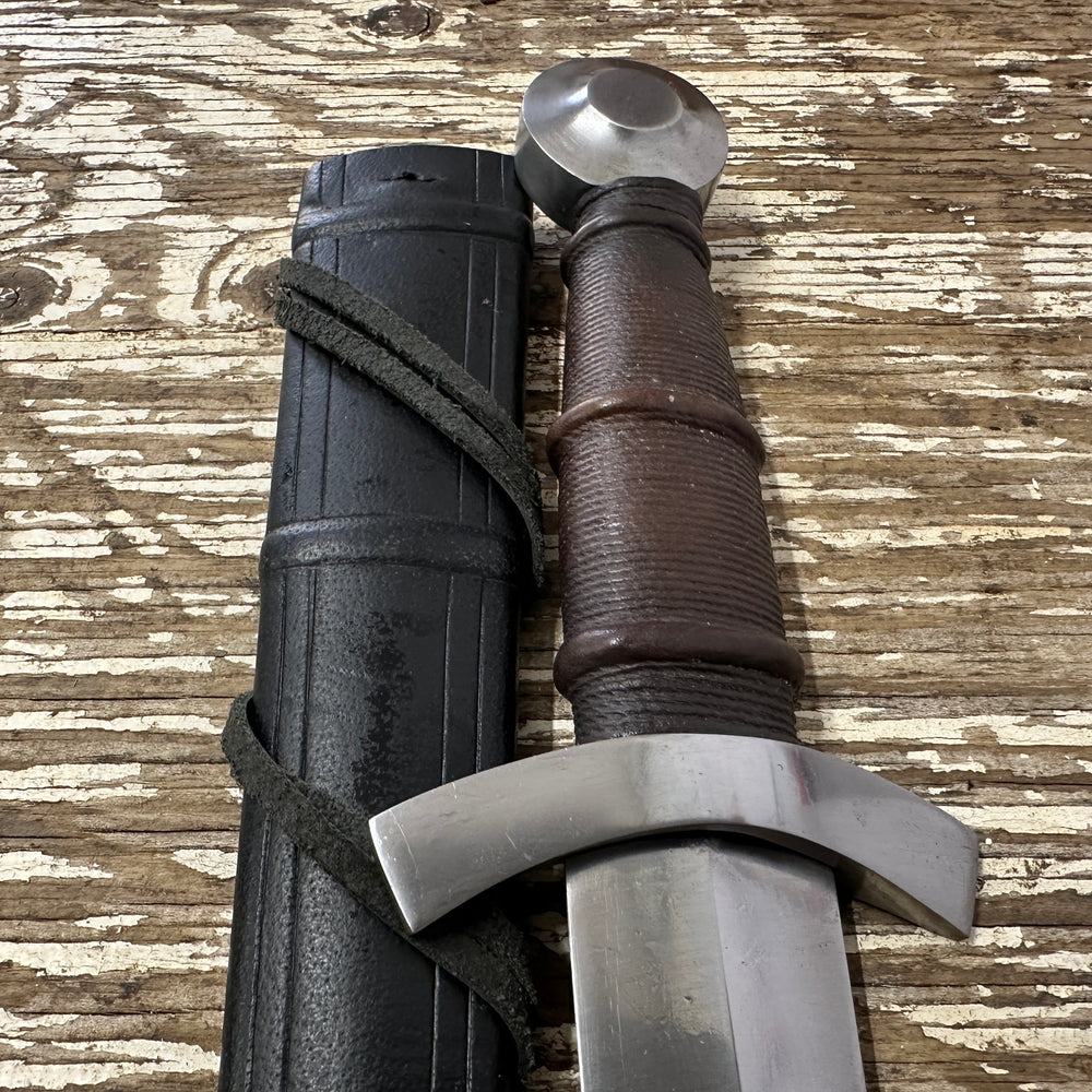 
                  
                    14thC Quillon Dagger with a black scabbard
                  
                