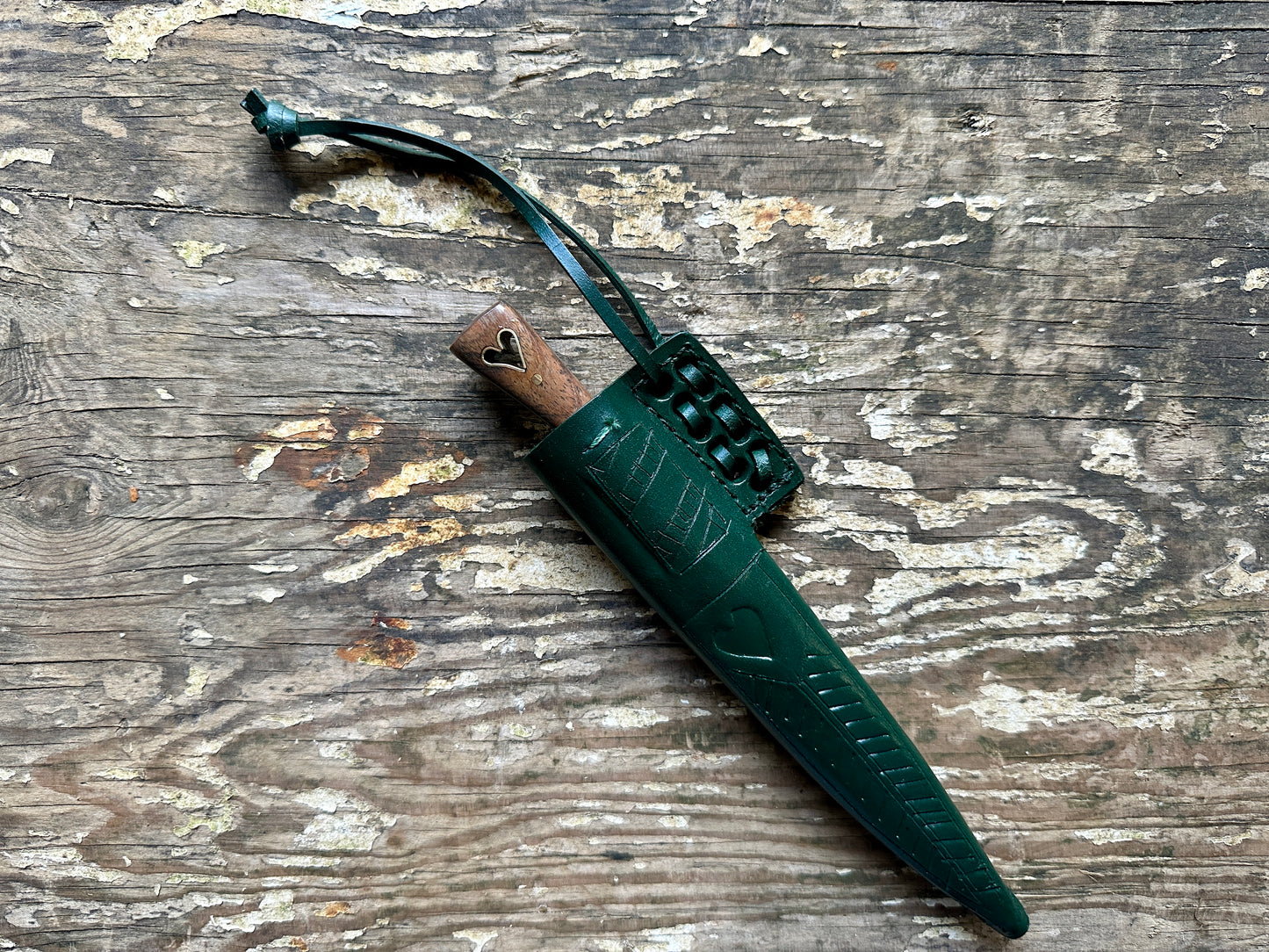 
                  
                    Heart eating knife with a  inside a green sheath
                  
                