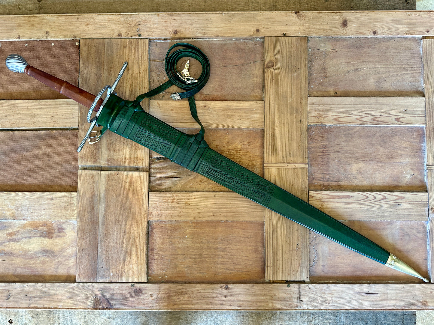 
                  
                    German War Sword in a green scabbard
                  
                