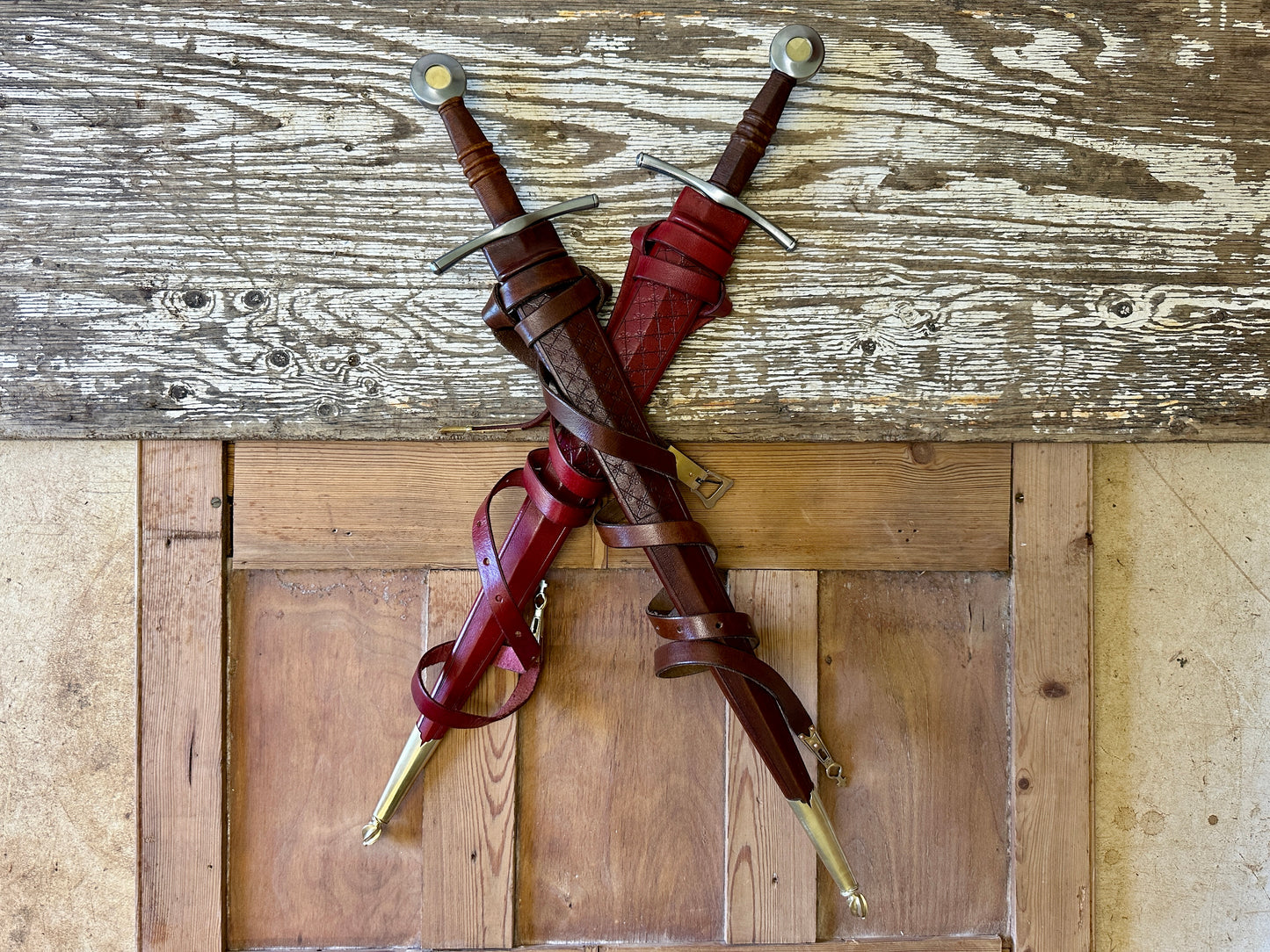 
                  
                    two swords, one in a red and one in a brown scabbard.

                  
                