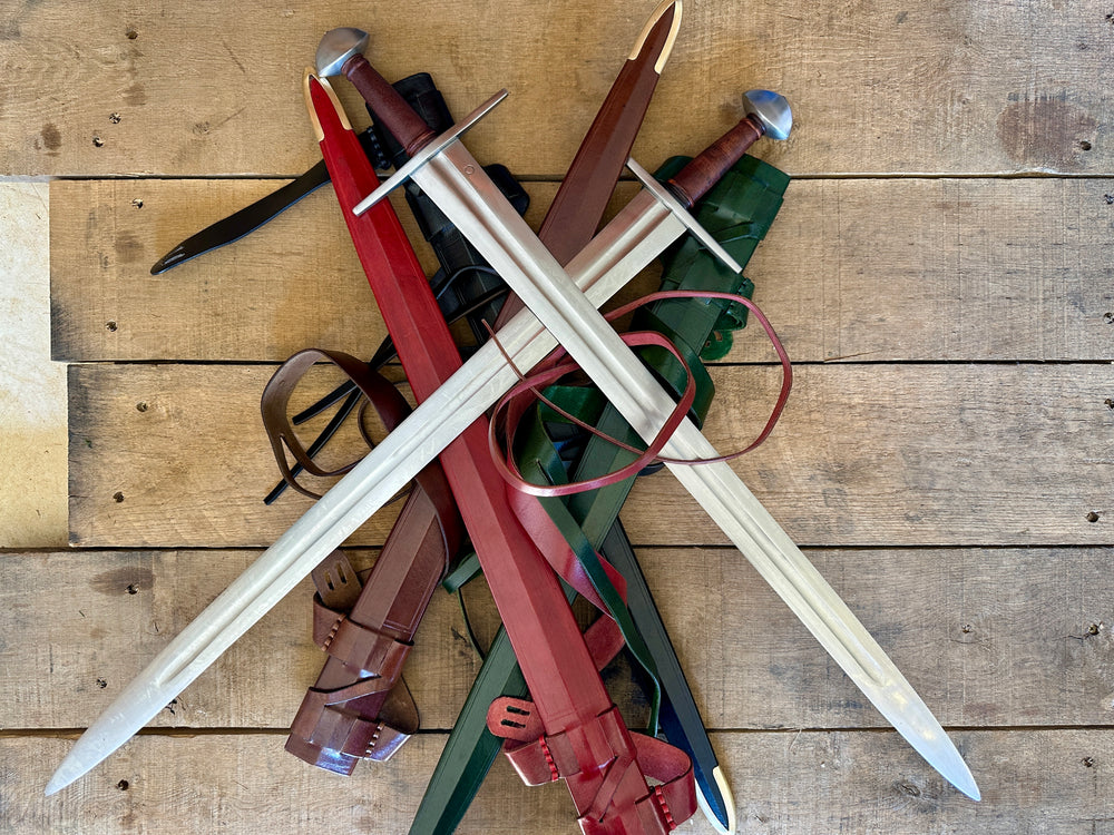 Two crossed Viking Norman Brazil Nut  swords on a pile of sword scabbards