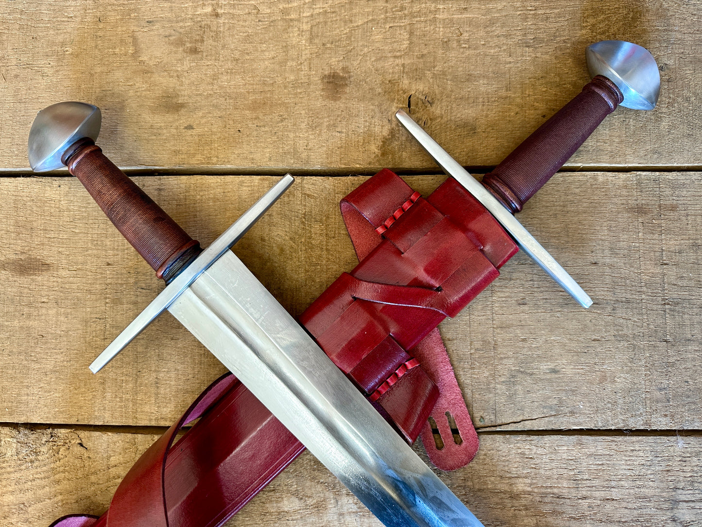
                  
                    Viking Norman Brazil Nut Sword one in a red scabbard, one out
                  
                