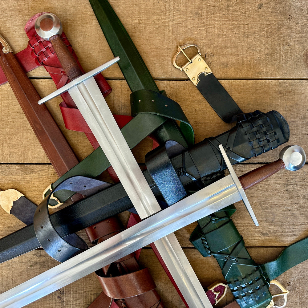 
                  
                    Close up of two swords crossed on a pile of scabbards
                  
                
