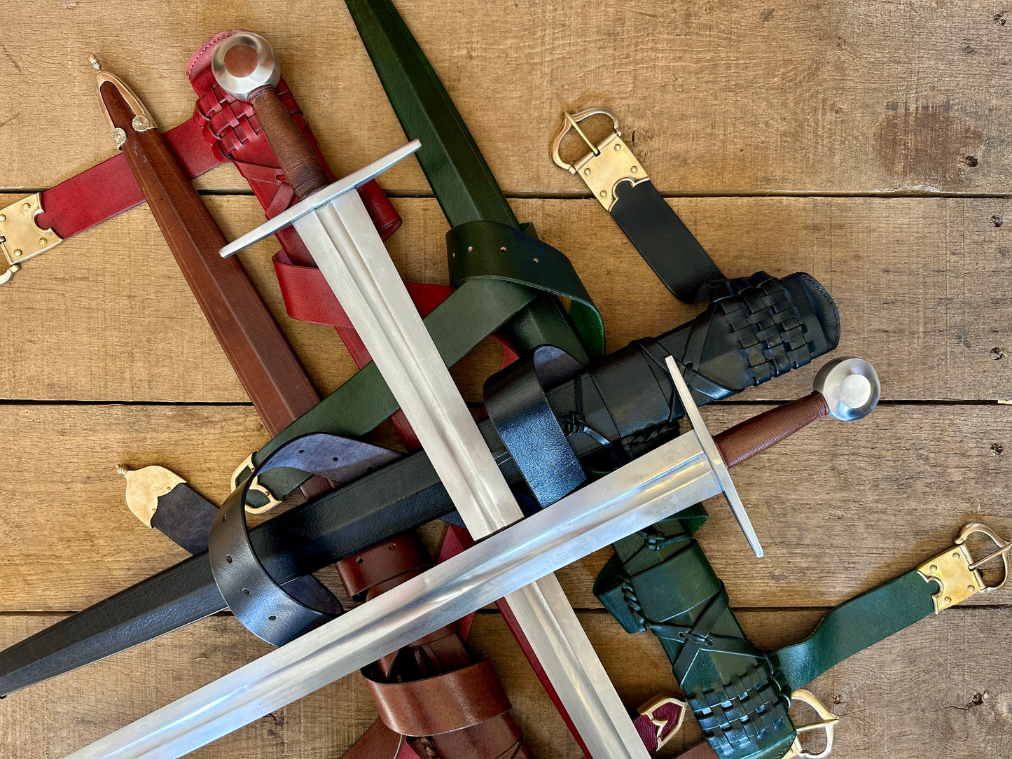 
                  
                    Close up of two swords crossed on a pile of scabbards
                  
                